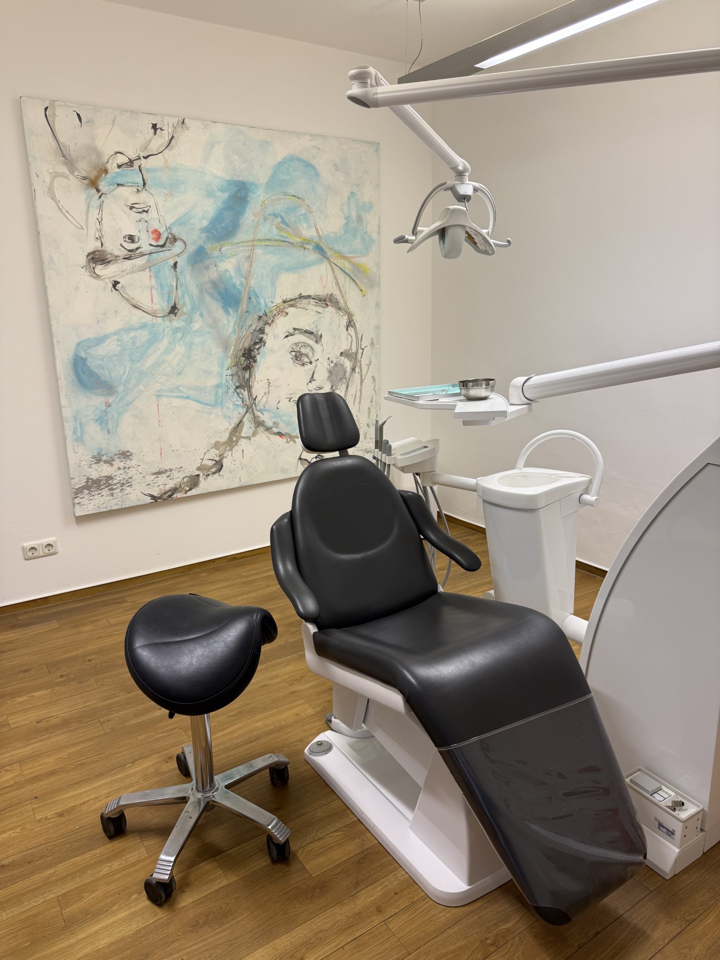 Behandlungsraum der Praxis mit blauem Kunstwerk