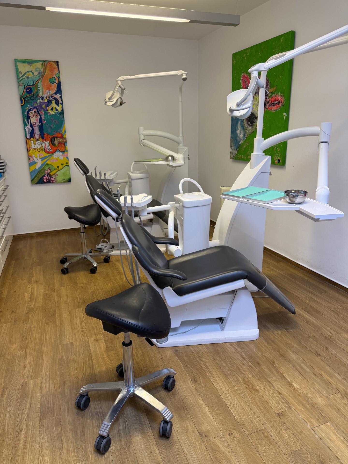 Behandlungsraum mit farbenfroher Kunst und moderner Ausstattung