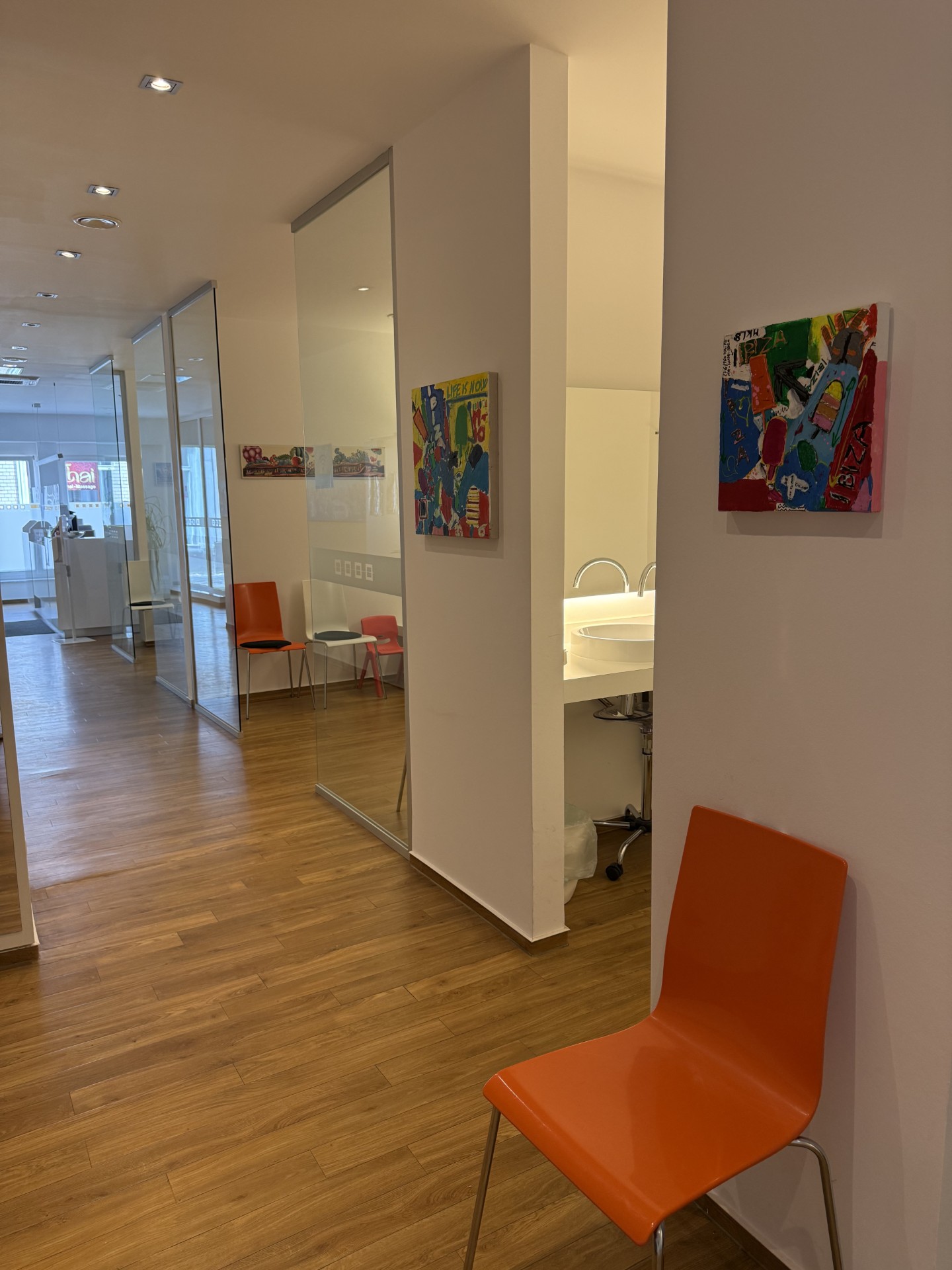Durchgang der Praxis mit farbenfroher Kunst und Blick in den Flur